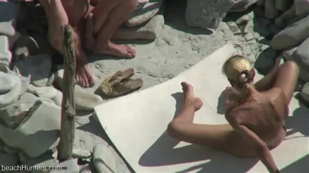 Blonde juega con un miembro de novio en una playa nudista
