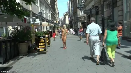 Rubia desnuda caminar a lo largo de las concurridas calles