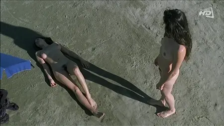 La belleza desnuda admira a su novia en una playa salvaje