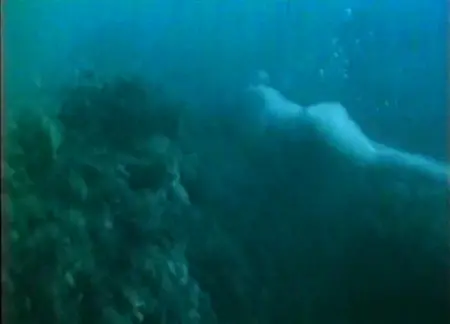 La belleza desnuda nade bajo el agua a gran profundidad