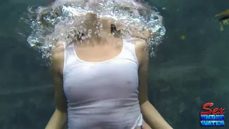 Una chica delgada nada bajo el agua y se sacude