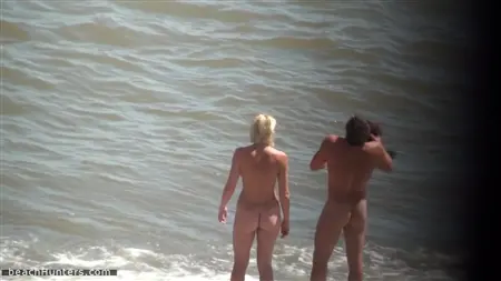 Mira a los nudistas desnudos en la playa