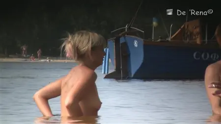 Los chicos y chicas desnudos rusos nadan en el río