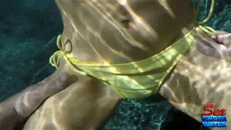Una mujer en traje de baño se masturba bajo el agua