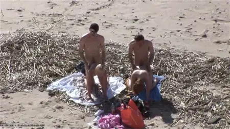 Una multitud de chicos en la playa deja en un círculo de dos prostitutas