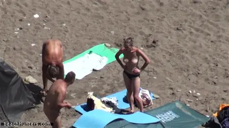 Los ávidos nudistas disfrutan de unas vacaciones en su playa salvaje favorita