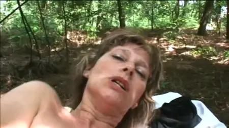 Una mujer madura en el bosque muestra sus encantos y joder con un hombre